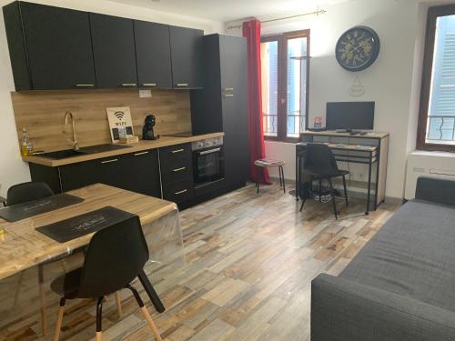 une cuisine avec des armoires noires, une table et des chaises dans l'établissement Sanary Paradise Port Climatisé, à Sanary-sur-Mer