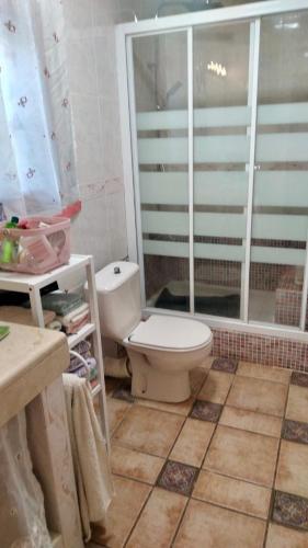a bathroom with a toilet and a glass shower at Villa di Esperanza in Comarruga