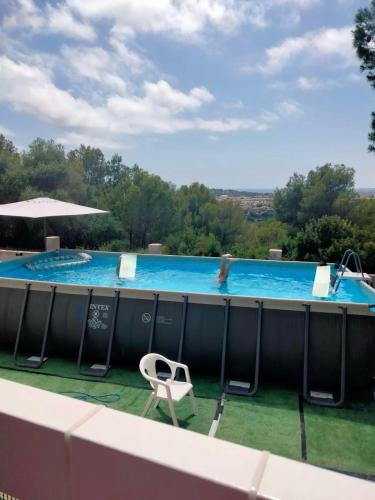 a large swimming pool with a white chair and a white chair at Villa di Esperanza in Comarruga