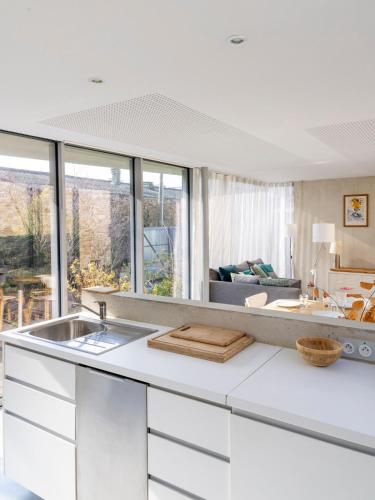 une cuisine avec un évier et un salon dans l'établissement Habiter la ville, un art contemporain, à Vannes