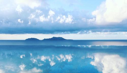 a large body of water with clouds and mountains in the background at Lagremha Villa in Agios Pavlos