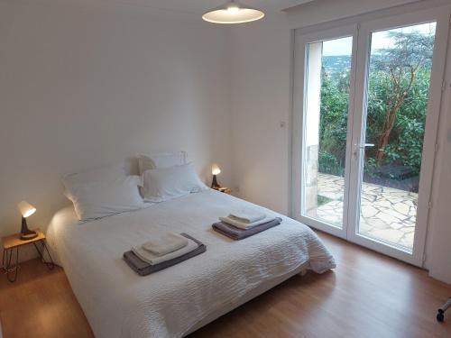 une chambre blanche avec un lit avec des serviettes dessus dans l'établissement Villa Serenite, aux Issambres