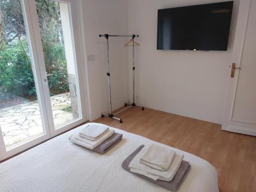 - une chambre avec 2 serviettes sur un lit et une télévision dans l'établissement Villa Serenite, aux Issambres