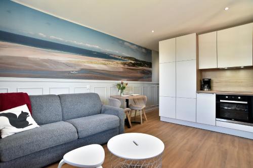 un salon avec un canapé et une table dans l'établissement Cécile 11 - A 200m de la plage, à Fréhel