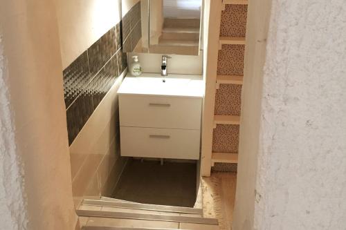 une salle de bain avec un lavabo blanc et un miroir dans l'établissement Jolie maison de ville au cœur de Pomerols, à Pomérols