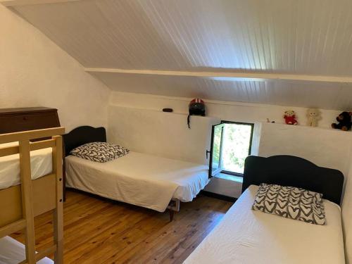 une petite chambre avec deux lits et une fenêtre dans l'établissement Maison familiale, à La Salvetat-sur-Agout