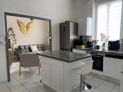 une cuisine avec un comptoir et un salon dans l'établissement Jolie maison de ville au cœur de Pomerols, à Pomérols