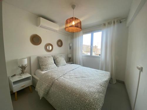 une chambre blanche avec un lit et une fenêtre dans l'établissement Jolie maison de ville au cœur de Pomerols, à Pomérols