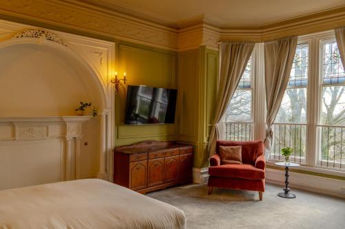 a bedroom with a bed and a tv and a chair at The Newcastle Residence Cozy & Modern Flats in The Park Estate in Nottingham
