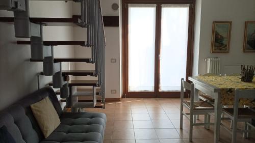 a living room with a blue couch and a table at Ca' Bice in Costermano sul Garda