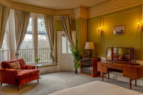 a bedroom with a bed and a chair and a desk at The Newcastle Residence Cozy & Modern Flats in The Park Estate in Nottingham