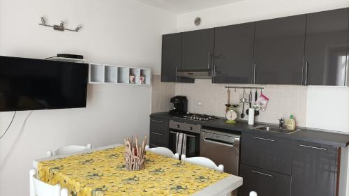 a kitchen with black cabinets and a table with chairs at Ca' Bice in Costermano sul Garda