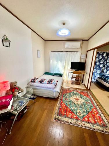 a bedroom with a bed and a table and a rug at Shirahama in Miyazaki