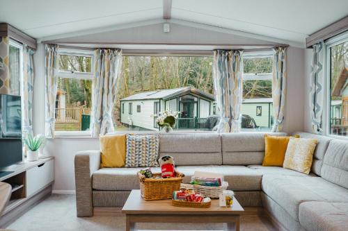 a living room with a couch and a table at Beautiful 3bed Caravan on Windermere - on White Cross Bay Holiday Park in Troutbeck Bridge