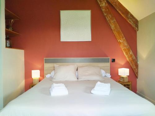 une chambre avec un lit blanc avec deux oreillers dans l'établissement AU NID DOUILLET DE LA FERME CHAUVET, à Chantenay-Villedieu