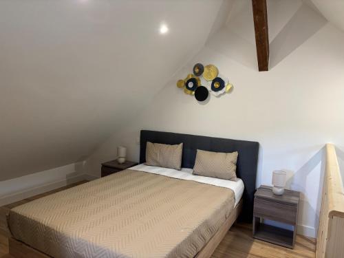 a bedroom with a bed and a clock on the wall at Appartement Sous les Etoiles pour 6 personnes in Saint-Nectaire