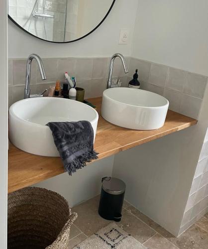 une salle de bain avec un lavabo blanc et un miroir dans l'établissement La planque en re, à Sainte-Marie de Ré