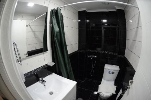a bathroom with a sink and a toilet and a mirror at Crown Resort by Diomedes Group in Nea Skioni