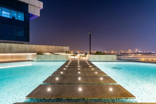 a pool at night with a bench and a building at Missoni Luxury Life Suite DPA Direct Pool Access in Dubai