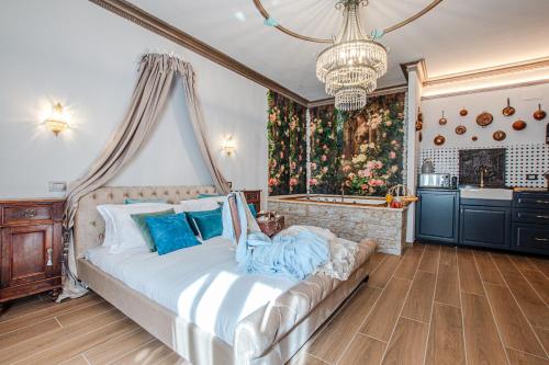 a bedroom with a large white bed with blue pillows at Altalena Luxury Rooms and Spa in Siena