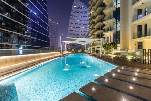 a large swimming pool in a city at night at Missoni Luxury Life Suite DPA Direct Pool Access in Dubai