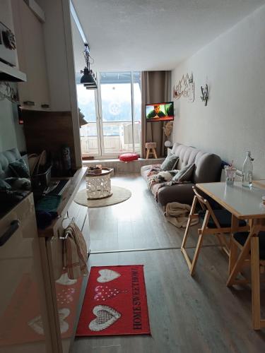 un salon avec un canapé et une table dans l'établissement Chaleureux studio Glovettes VILLARD DE LANS, à Villard-de-Lans