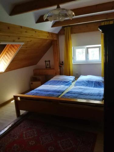 a bedroom with a bed with a blue comforter at Mária Villa in Balatonboglár