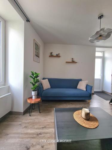 un salon avec un canapé bleu et une table dans l'établissement Le Pautin T3 cozy à 10 min du Puy duFou, à Saint-Malo-du-Bois