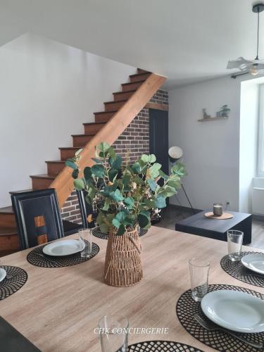 une table de salle à manger avec un vase de fleurs dessus dans l'établissement Le Pautin T3 cozy à 10 min du Puy duFou, à Saint-Malo-du-Bois