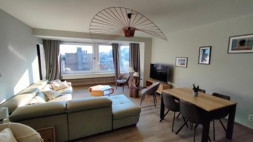 ein Wohnzimmer mit einer Couch und einem Tisch in der Unterkunft Sea-scape - De Panne - spacieux appartement très bien situé avec vue sur mer in De Panne
