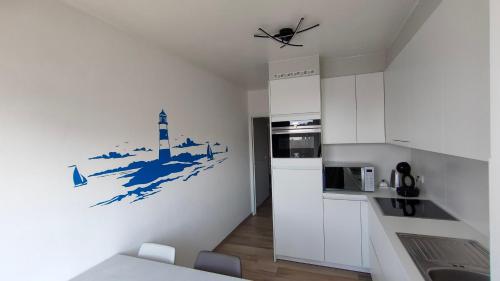 eine Küche mit einem Gemälde eines Leuchtturms an der Wand in der Unterkunft Sea-scape - De Panne - spacieux appartement très bien situé avec vue sur mer in De Panne
