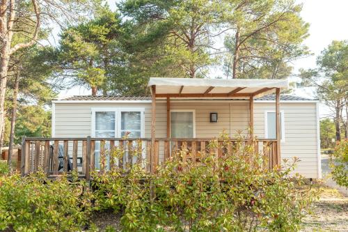 a tiny house in the woods with a deck at Camping Les Gorges de Provence in Saint-Laurent-du-Verdon