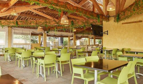 un restaurant avec des tables et des chaises dans une salle dans l'établissement Camping Les Gorges de Provence, à Saint-Laurent-du-Verdon