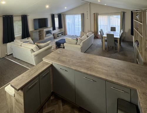 a kitchen and living room with a couch and a table at Yellow Bush Lodge in Haven Street