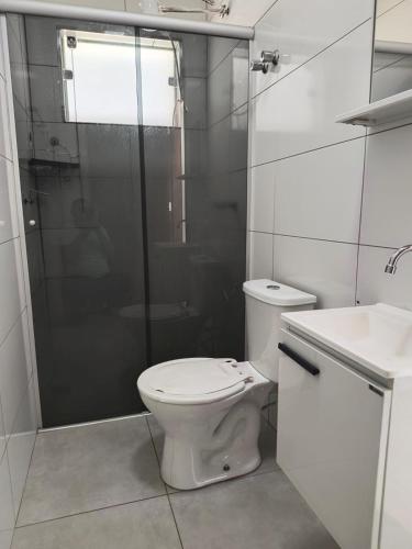 a bathroom with a toilet and a shower and a sink at Apartamento 1 andar in Bebedouro