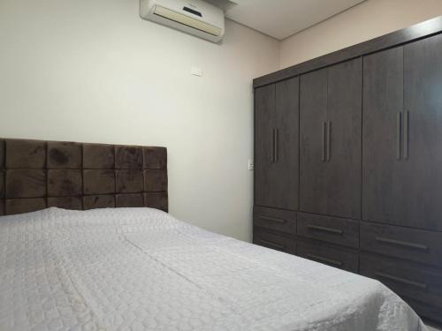 a bedroom with a large bed and a dresser at Apartamento 1 andar in Bebedouro
