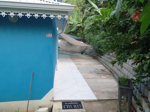a blue door with a sign in front of a building at Haut de villa indépendant, vue et accès mer, 100m de la plage, idéal famille in La Trinité