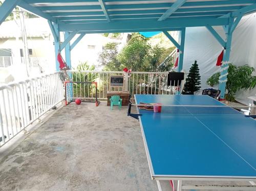 a blue ping pong table on a patio at Haut de villa indépendant, vue et accès mer, 100m de la plage, idéal famille in La Trinité