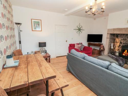 a living room with a couch and a table at The Smithy in Chathill