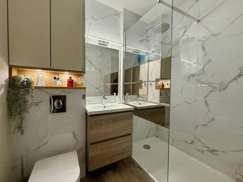 une salle de bain avec deux lavabos et une douche en verre dans l'établissement Studio rénové à 350m de la plage, Arcachon (4 pers) - FR-1-433-132, à Arcachon