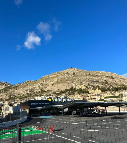 a gas station with a mountain in the background at La guarida rústica del zorro in Jijona