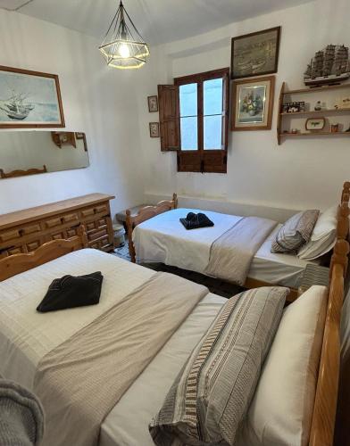 a room with three beds and a window at La guarida rústica del zorro in Jijona