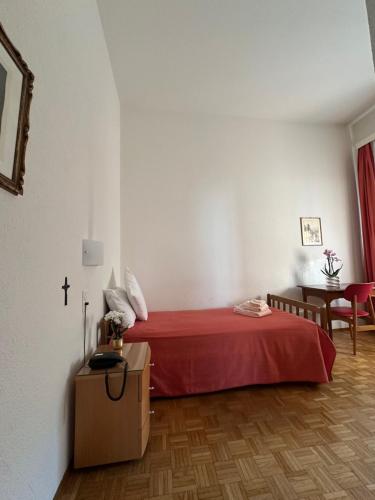 a room with a bed with a cross on the wall at Casa Santa Birgitta in Lugano
