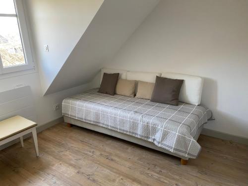 a bed sitting in a room with a stair at Maison - 2 chambres - Terrasse - Babyfoot in Verton