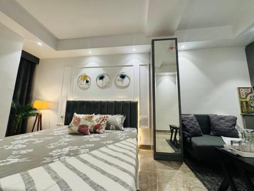 a bedroom with a bed and a mirror and a couch at luxury private studio In Zirakpur in Ghaggar