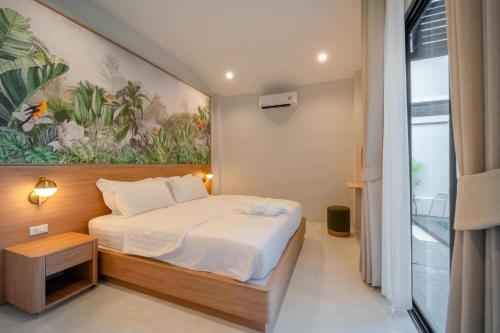 a bedroom with a bed and a painting on the wall at The marin poolvilla aonang in Ban Chong Phli
