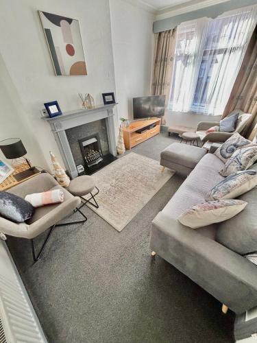 a living room with two couches and a fireplace at Entire holiday home in Blackpool with free parking and a private patio garden in Blackpool