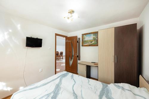 a bedroom with a bed and a desk at Casa Cristiana in Bologa