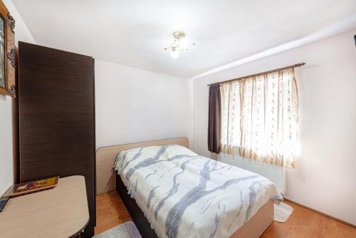 a small bedroom with a bed and a window at Casa Cristiana in Bologa
