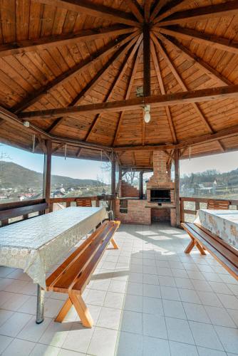 a large wooden pavilion with a table and a fireplace at Casa Cristiana in Bologa